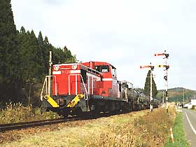 A tanker train passing by a semaphore