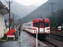 The stationmaster seeing off the train at Yuse-Onsen Station.